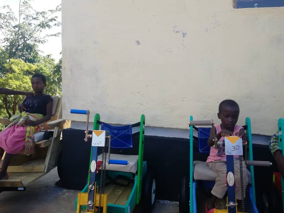 A child seated in an adapted mobility tricycle provided through RECOAT's inclusive education support